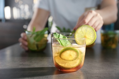 Photo of Glass with delicious mint julep cocktail and blurred person on background