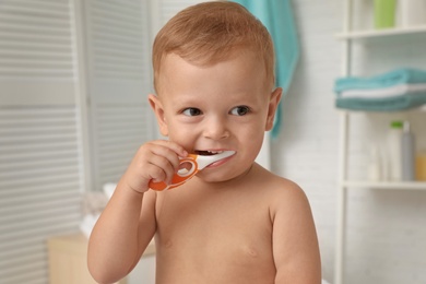 Photo of Cute little boy with toothbrush on blurred background