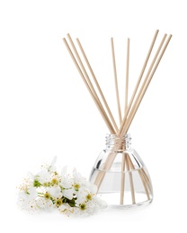 Photo of Aromatic reed freshener and flowers on white background