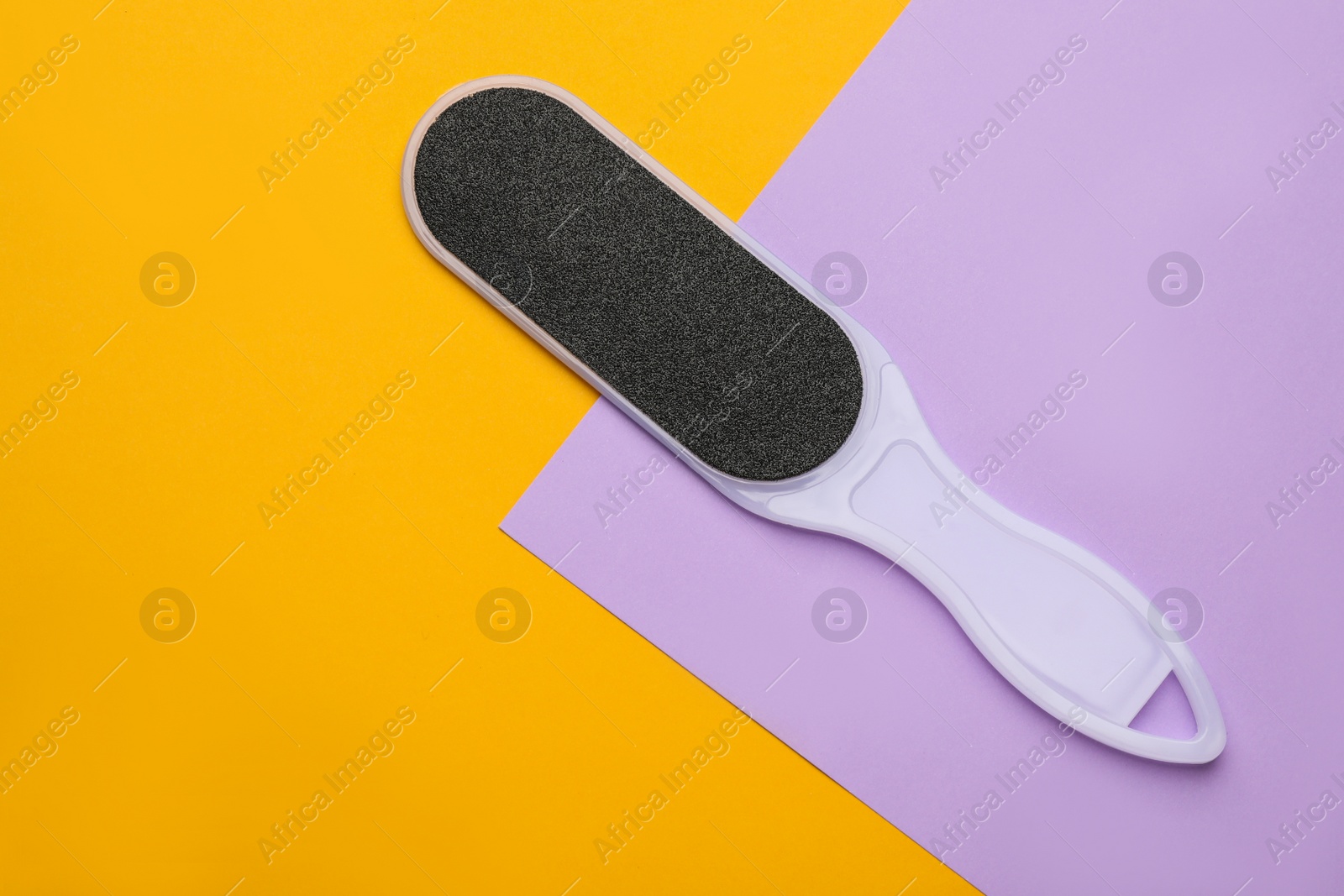 Photo of Foot file on color background, top view with space for text. Pedicure tool