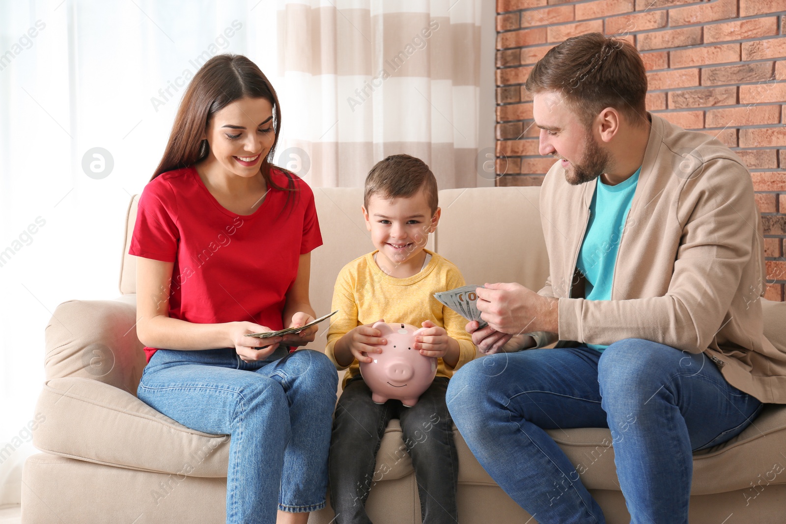 Photo of Happy family with piggy bank and money at home