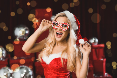Image of Beautiful young woman in Christmas costume against blurred lights