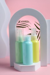 Cosmetic travel kit and geometric figures on pink background. Bath accessories