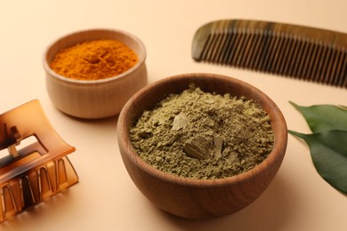 Photo of Comb, barrette, henna and turmeric powder on beige background, closeup. Natural hair coloring