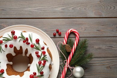 Photo of Flat lay composition with traditional Christmas cake and decorations on wooden table, space for text