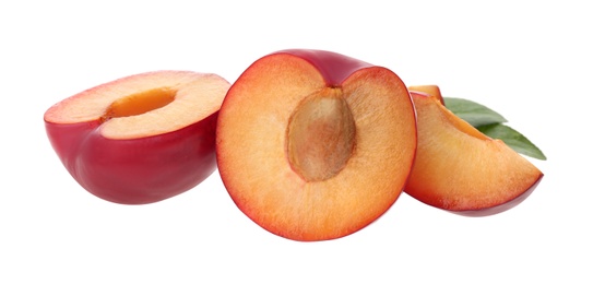 Photo of Cut fresh ripe plums with green leaves isolated on white