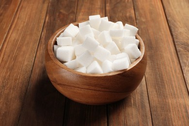 Photo of Bowl with sugar cubes on wooden table