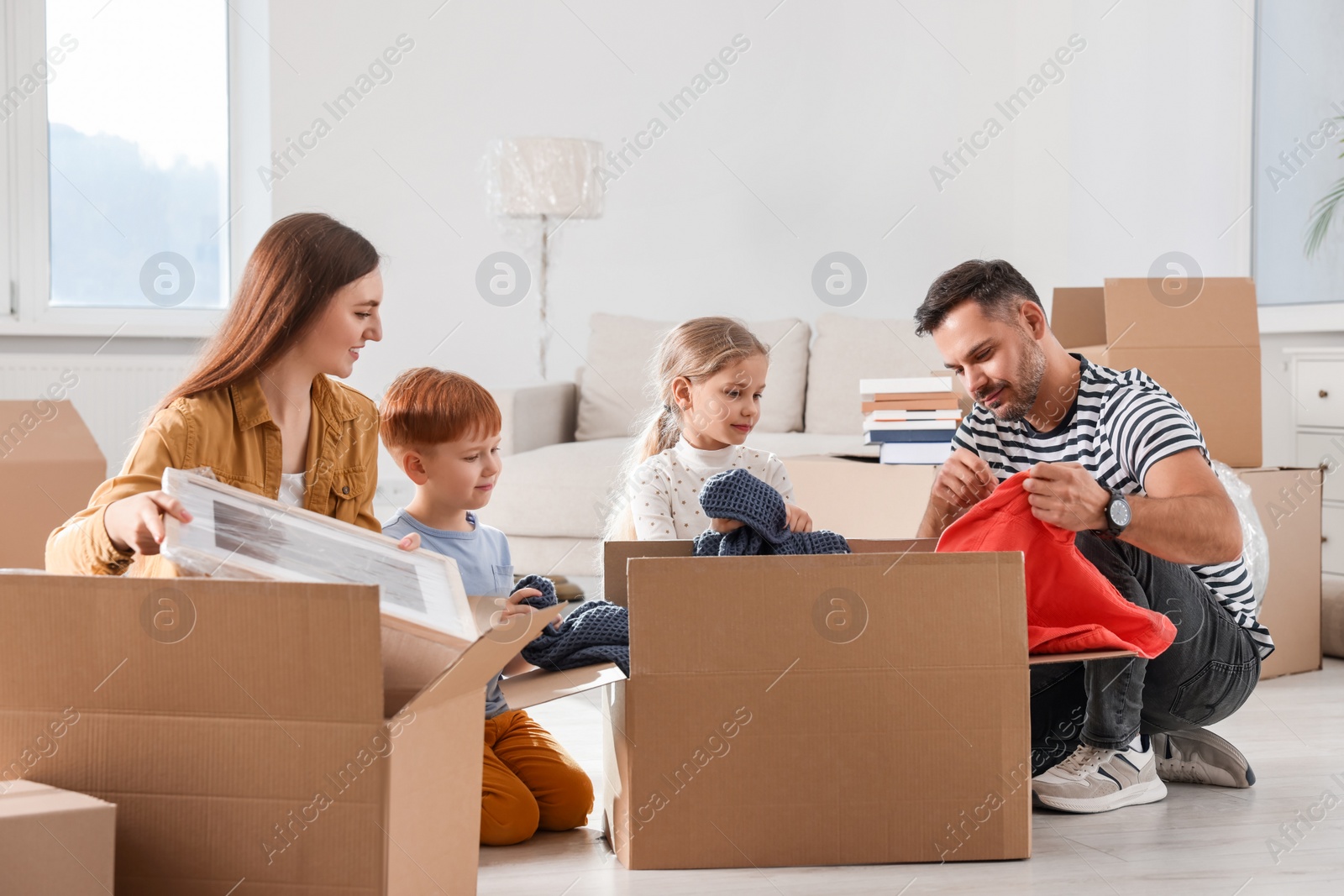 Photo of Family unpacking boxes in new apartment. Moving day