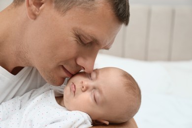 Photo of Father holding his cute sleeping baby at home, closeup