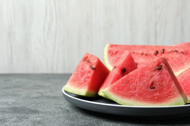 Photo of Delicious fresh watermelon slices on grey table. Space for text