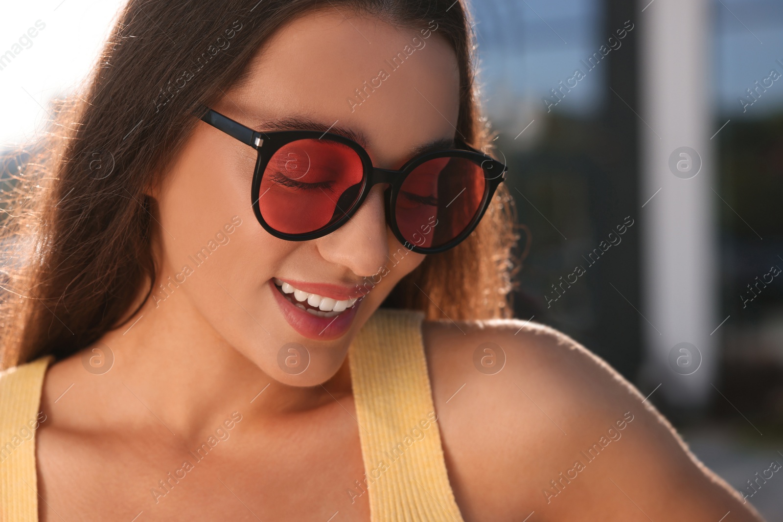 Photo of Beautiful smiling woman in sunglasses outdoors on sunny day