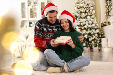 Happy couple with Christmas gift box at home