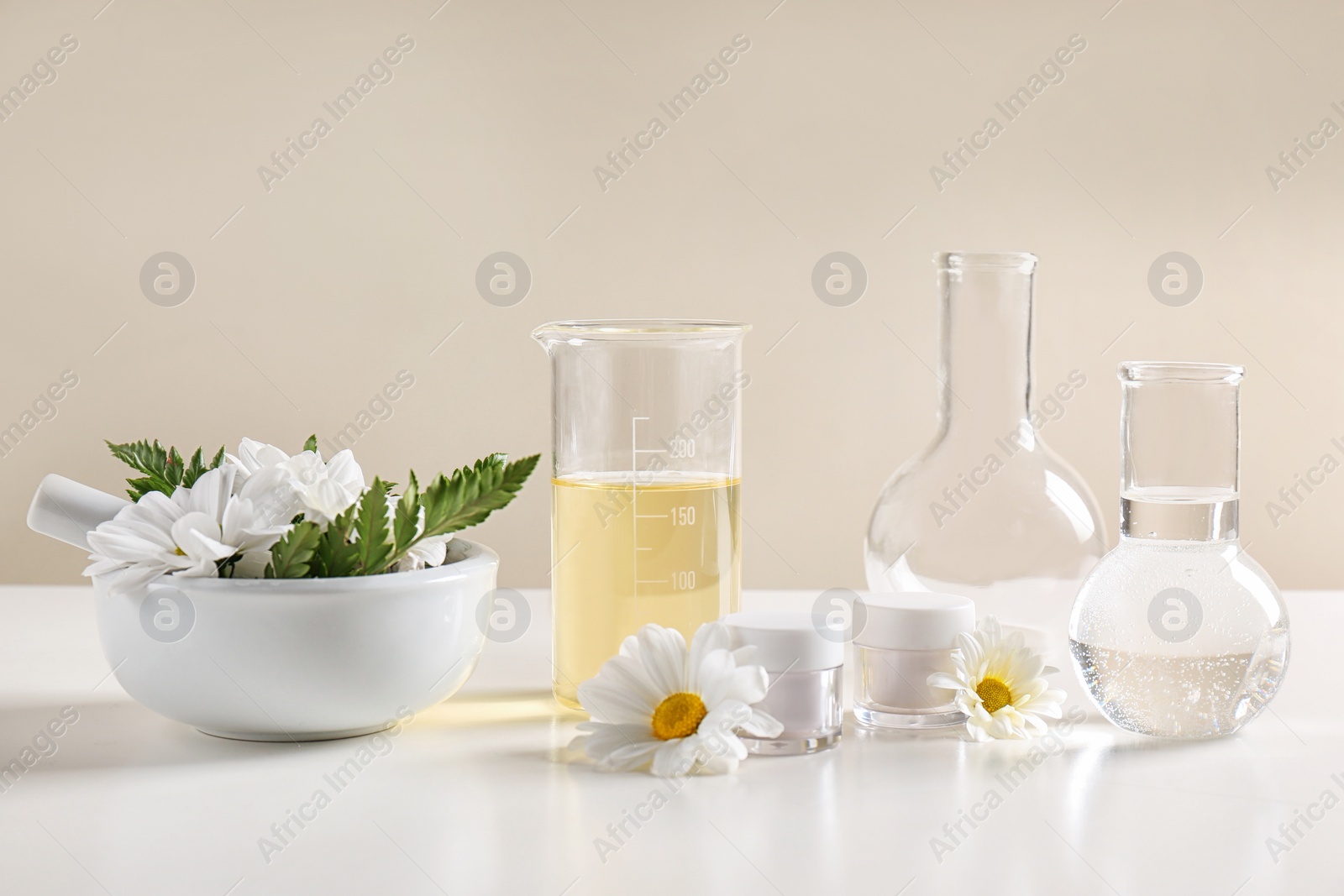 Photo of Skin care products, ingredients and laboratory glassware on table. Dermatology research