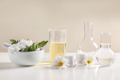 Skin care products, ingredients and laboratory glassware on table. Dermatology research