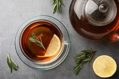 Photo of Aromatic herbal tea with rosemary and lemon on grey table, flat lay