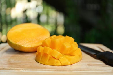 Photo of Cut ripe juicy mango on wooden board