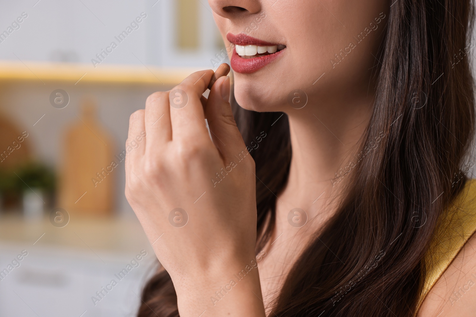 Photo of Woman taking vitamin pill at home, closeup