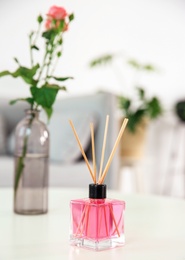 Photo of Aromatic reed air freshener on table indoors