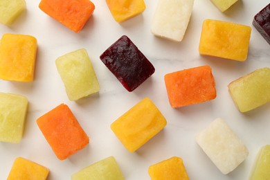 Frozen vegetable puree cubes on white table, flat lay