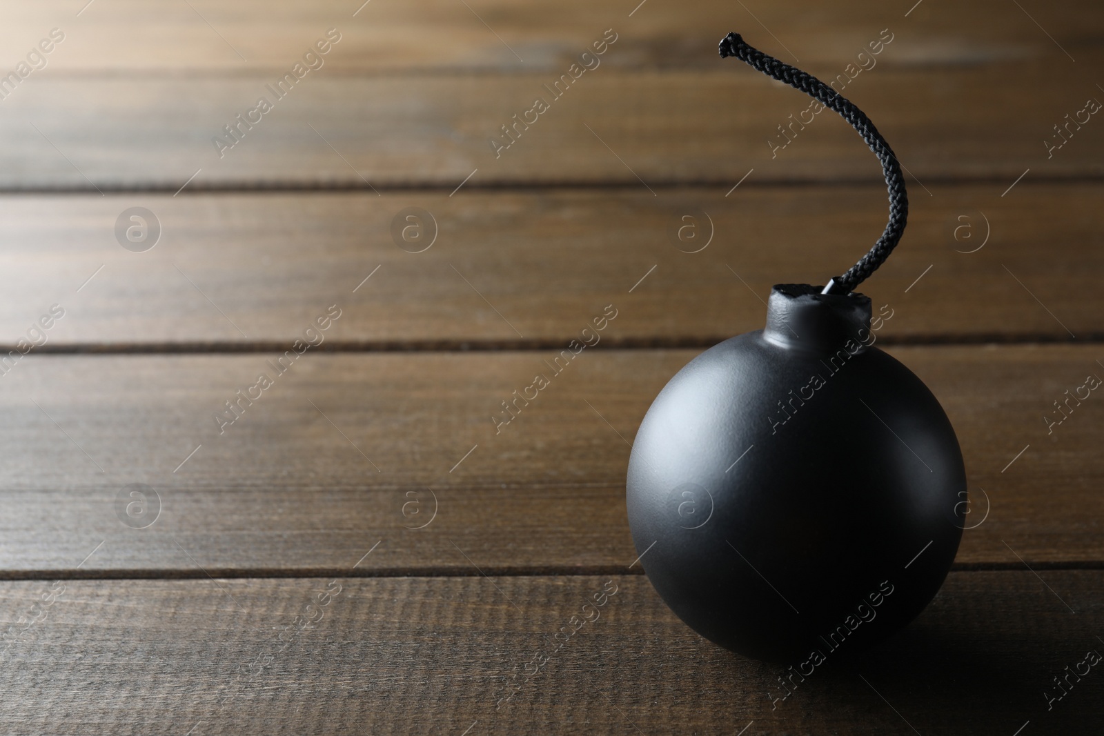 Photo of Old fashioned fuse bomb on wooden table. Space for text