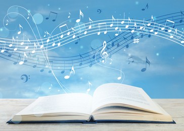 Image of Music flowing from book. Musical symbols flying over tome on white wooden table against sky