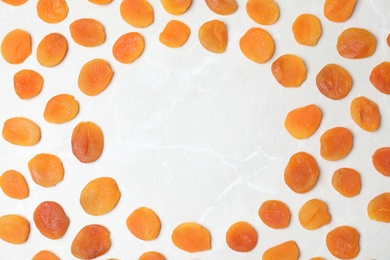 Frame made of apricots on light background, top view with space for text. Dried fruit as healthy food