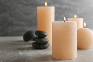 Photo of Burning candles and spa stones on table. Space for text