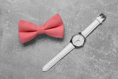 Photo of Stylish coral bow tie and wristwatch on light grey background, flat lay