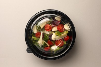 Tasty food in container on light background, top view