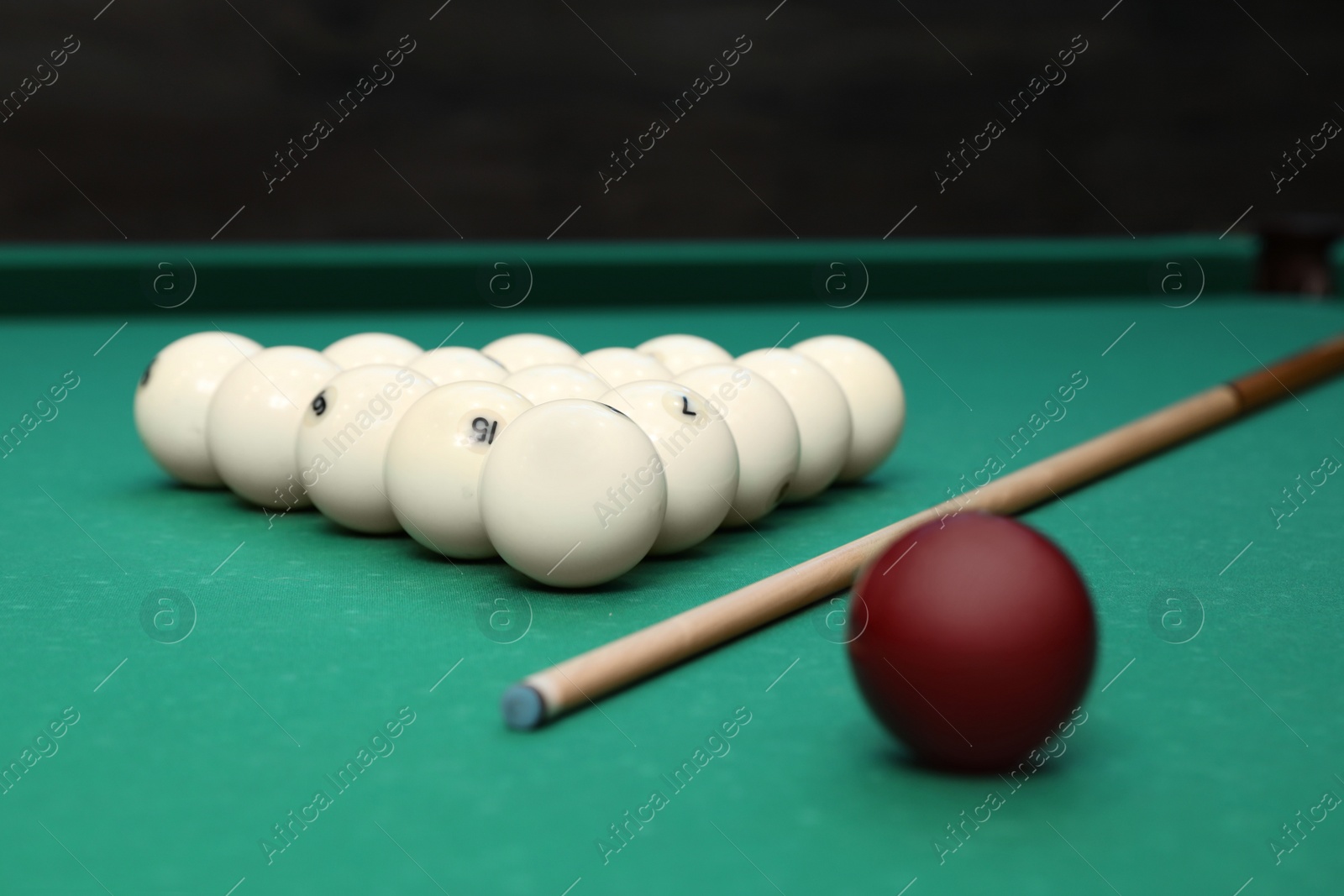 Photo of Billiard balls and cue on table indoors