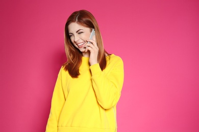 Portrait of beautiful woman talking on phone against color background. Space for text