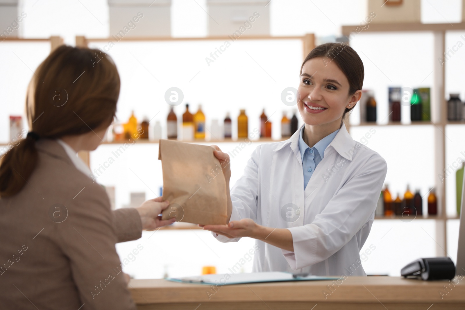 Photo of Pharmacist giving medicine to customer in drugstore