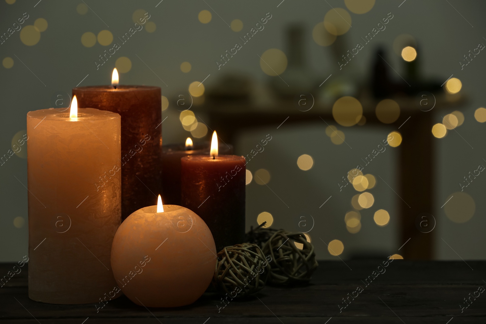 Photo of Burning candles on wooden table indoors. Space for text