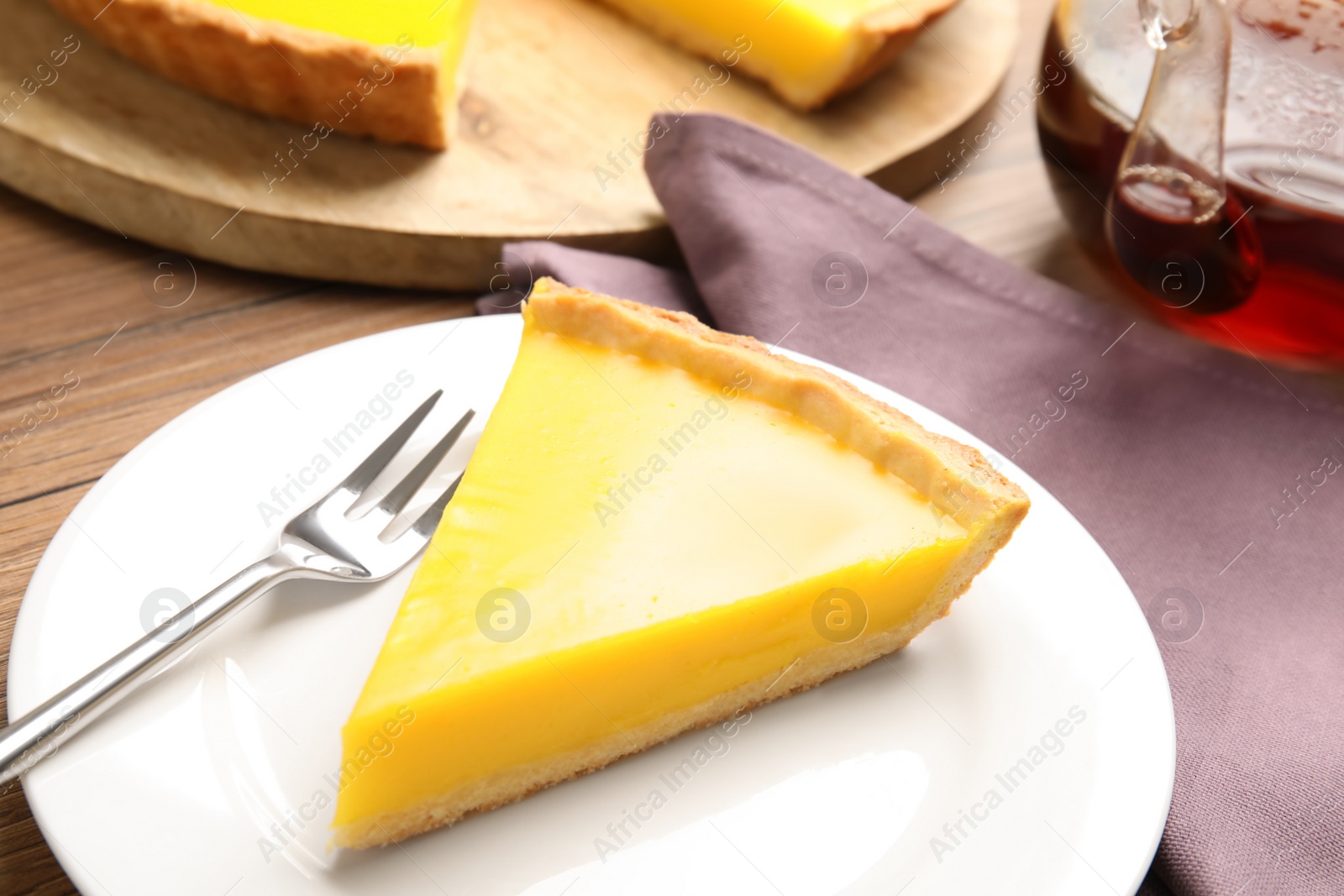 Photo of Slice of delicious homemade lemon pie on wooden table