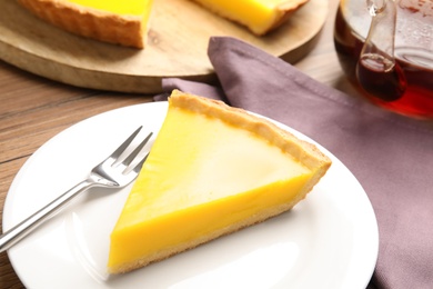 Photo of Slice of delicious homemade lemon pie on wooden table