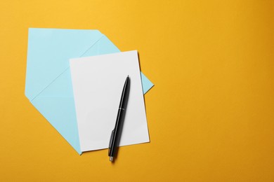 Blank sheet of paper, letter envelope and pen on orange background, top view. Space for text