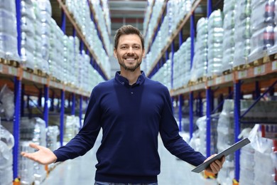 Photo of Happy manager holding clipboard in warehouse with lotsproducts