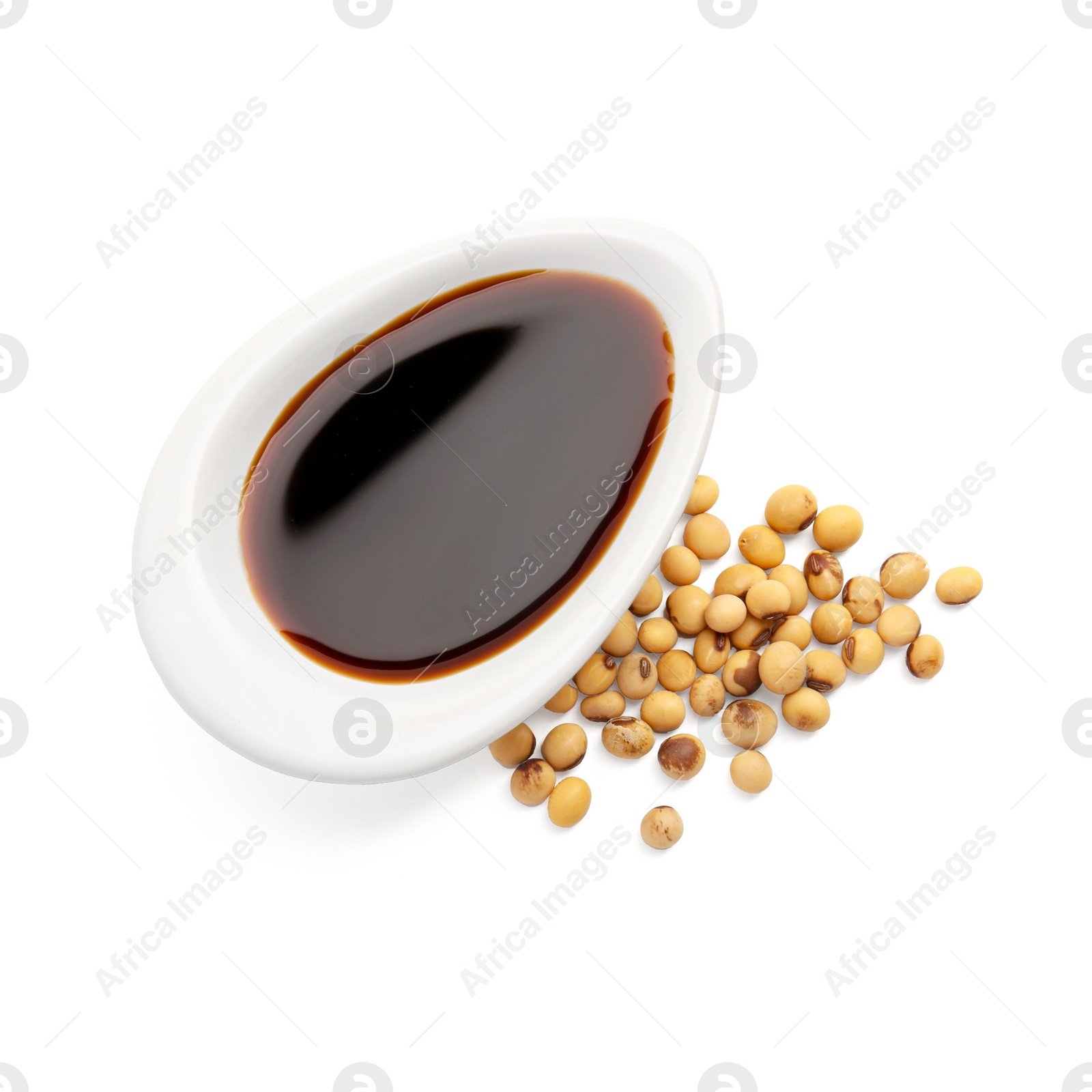 Photo of Tasty soy sauce in gravy boat and soybeans isolated on white, top view