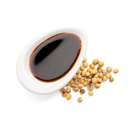 Photo of Tasty soy sauce in gravy boat and soybeans isolated on white, top view