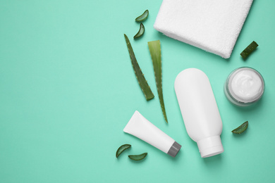 Flat lay composition with aloe vera and cosmetic products on turquoise background. Space for text