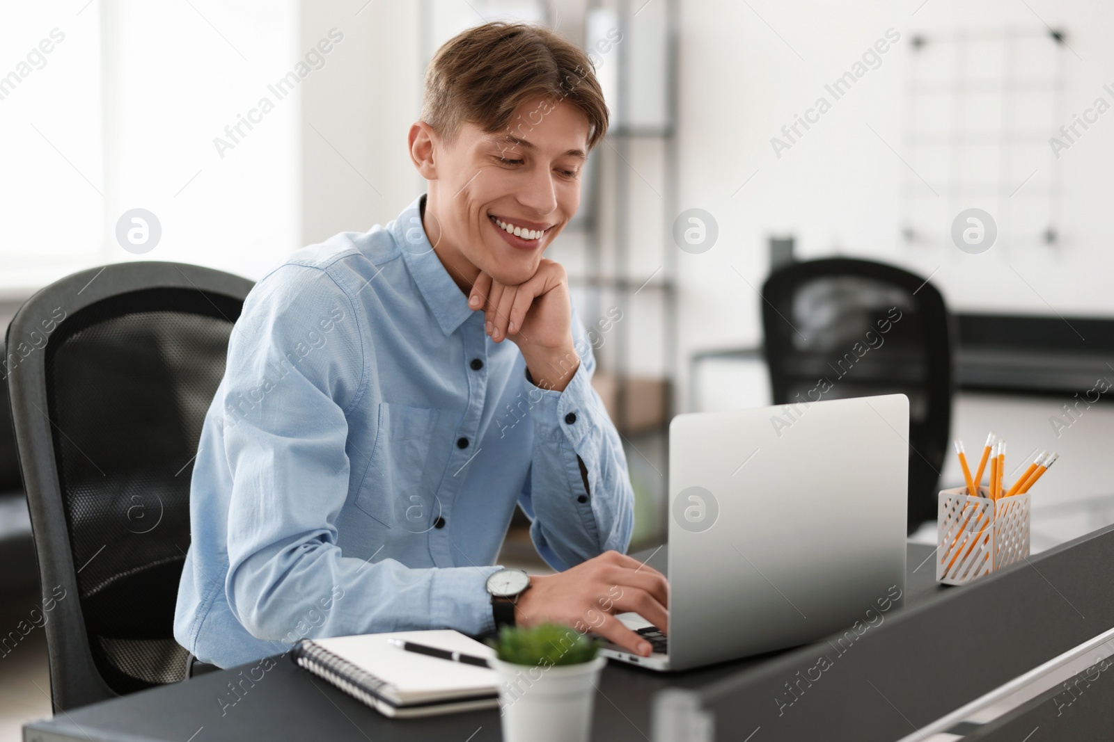 Photo of Man watching webinar at table in office