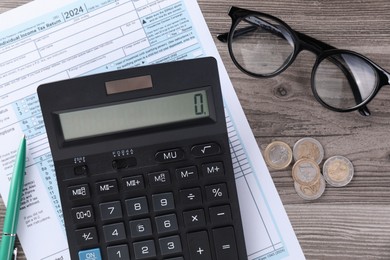 Photo of Tax accounting. Calculator, document, pen and coins on wooden table, flat lay