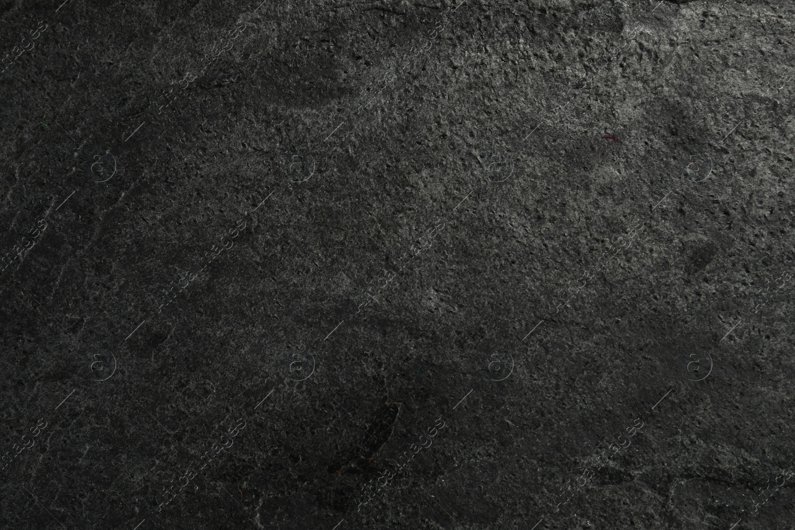 Photo of Texture of dark grey stone surface as background, closeup