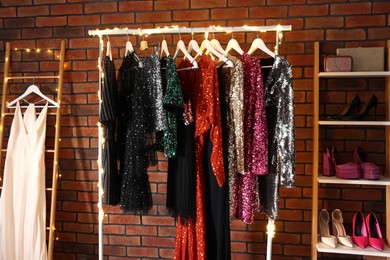 Photo of Collection of different beautiful women's party dresses and shoes in showroom. Stylish trendy clothes for high school prom
