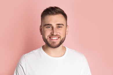 Young man with healthy teeth on color background