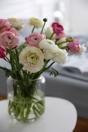 Photo of Bouquet of beautiful ranunculuses on table in bedroom