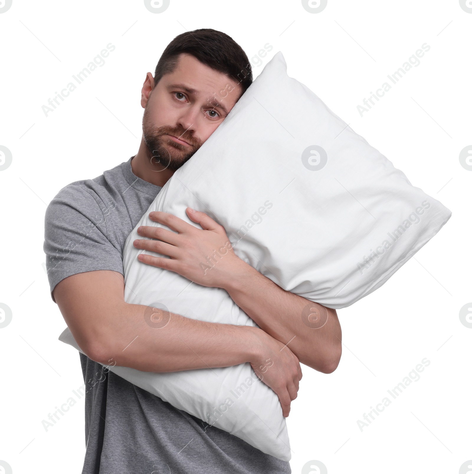 Photo of Unhappy man with pillow on white background. Insomnia problem