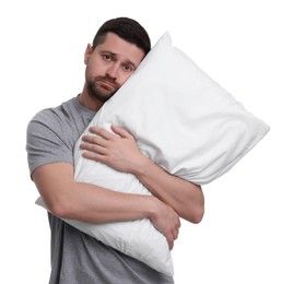 Photo of Unhappy man with pillow on white background. Insomnia problem