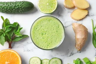 Photo of Flat lay composition with glass of delicious detox juice and ingredients on marble background