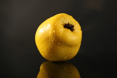 Photo of Tasty ripe quince with water drops on black mirror surface